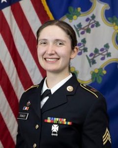 Rhiannon Trunzo in her dress Army uniform with the U.S. flag and the Connecticut State flag in the background.
