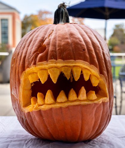 pumpkin with a ghoulish face carved in it